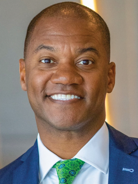 A Black man in suit smiling headshot