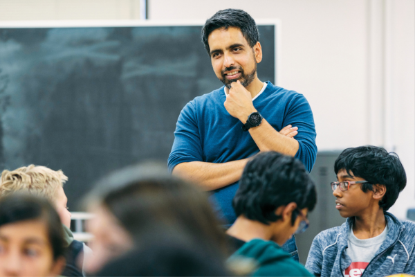 Photo of Sal Khan in classroom with students sitting at tables