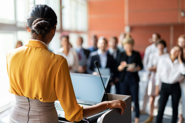 woman at podium in front of crowd
