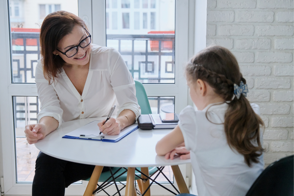 psychologist at table with young girl